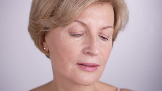 A sophisticated middleaged woman using cotton pad to remove make up and cleanse her skin. Skincare routine for aging skin. 4k high res