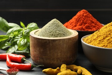 Different aromatic spices and herbs on black background, closeup