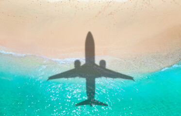 Airplane shadow flying over beautiful exotic tropical beach with sunny cay - Summer vacation travel...