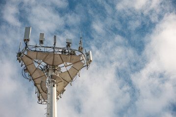 5g mobile network communication tower with cellular antenna transmitter and receiver, broadcasting 4g lte equipment, phone network station on sky with clouds background