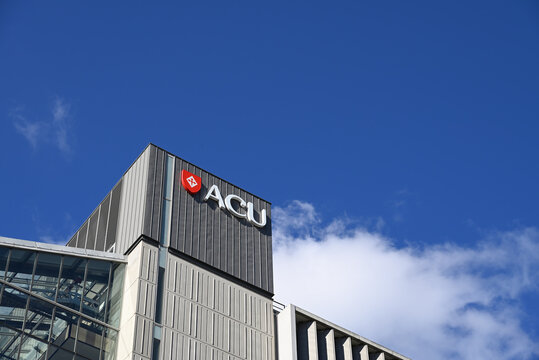 Australian Catholic University logo, featuring red shield with a cross, atop the Daniel Mannix Building at ACU's Melbourne campus