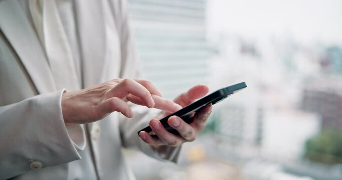 Woman, hands and phone at window for business, update schedule and planning in office. Trader, mobile or typing in Japanese agency for stock market research, investment opportunity or online feedback