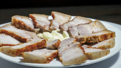 Slices of boiled pork meat with pepper served with garlic in a vibrant culinary display