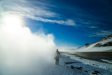 Man with camera standing in smoke cloud - Iceland