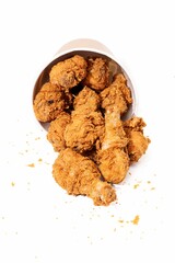 Crispy fried chicken spilling from a bucket