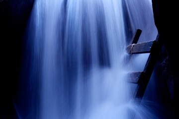 Blue hue on majestic waterfall and wooden ladder - closeup © DevinSuperTramp