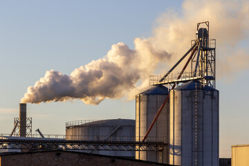 A factory that pollutes the air with harmful substances. Thick smoke against the sky