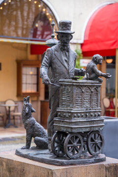Peque&ntilde;a escultura de un antiguo organillero frente a un restaurante en el centro comercial de la ciudad.  de Berl&iacute;n en Alemania