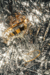 gold cocktail coupe glass on sparkling metallic silver background