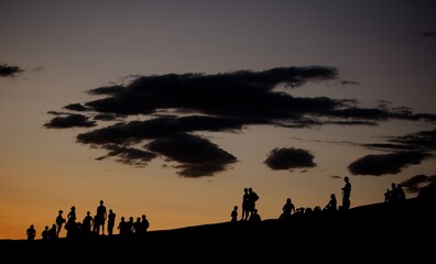 Naklejka premium Silhouette of groups of people on hillside at dusk