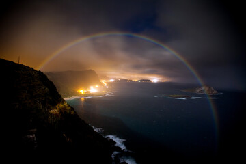Perfect rainbow over Hawaiian islands and ocean - sunset through clouds
