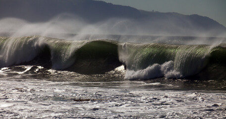 Greenish blue wave rolling and crashing, medium shot