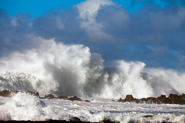 Rushing waves rolling over rocky island patch