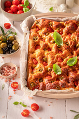 Hot focaccia with cherry tomatoes, olives and salt.