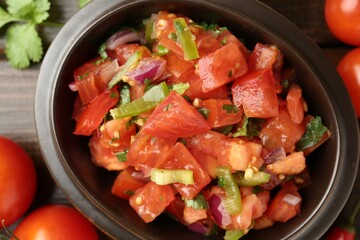 Delicious spicy salsa with ingredients on wooden table, closeup