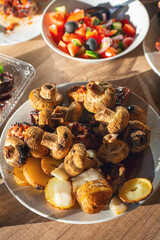 Pork shashlik, champignons, potatoes with lard fried on the grill in a plate on the table