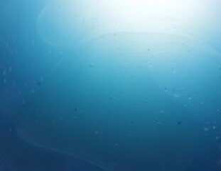 Una toma de cerca de varias burbujas de agua y aceite en movimiento en un fondo de color azul con...