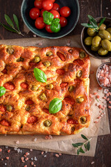 Homemade focaccia made of olives and cherry tomatoes.