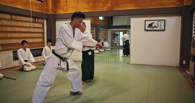 Sensei, student and bokken for fight, aikido and martial arts with fitness, kung fu and stick in Japan. Training, teaching and master for karate, battle and self defense class with exercise in dojo