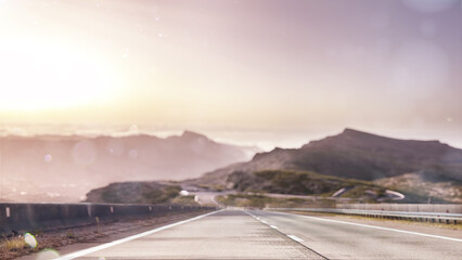 Beautiful blurred background. Empty space to display your advertising or branding campaign. Road and sunset in the mountains. Mountains in the background