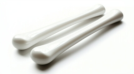 A pair of white claves, smooth and rounded, isolated on a white background to emphasize their simplicity and craftsmanship.