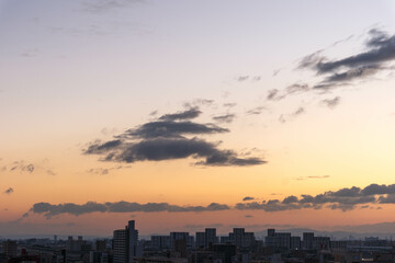 Fototapeta premium 都市の夜明け。高層ビルをシルエットにあたりはオレンジ色に染まる