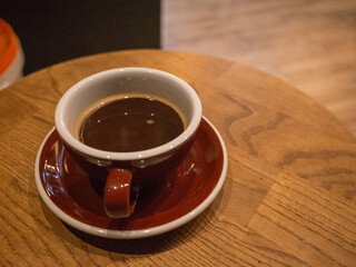 a cup of coffee on the wooden table inside cafe in podil