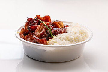 A white disposable plastic bowl filled with glazed stir-fried chicken and boiled rice, set against a white background.