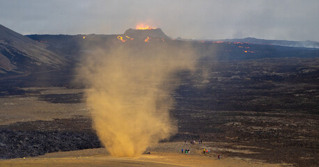 Volcano eruption in Iceland with dust whirl and distant lava flows