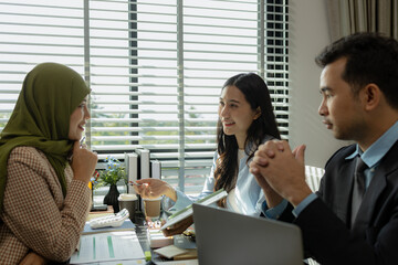group of businessmen are discussing in an office. businessmen of different culture are meeting to make products that are appropriate and religiously correct. A businesswoman is wearing a hijab.