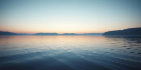 Obraz premium Soft focus on a serene lake at dawn with gentle blue hues blending into soft peach tones, peaceful morning atmosphere, serene lake scenery