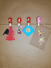 Christmas background brown paper new year 2025 numbers on decorative clothespins, xmas tree, Christmas gingerbread, mulled wine, Christmas candies
