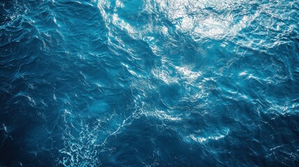 Fototapeta premium An aerial view of the ocean surface, with blue water and whitecaps.