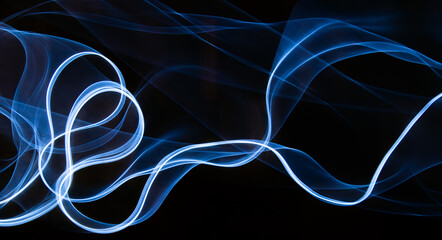 Photography of moving neon light with light trail on dark background, vibrant blue color