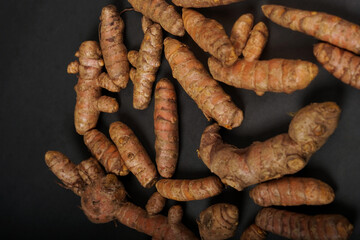 Fresh turmeric roots isolated on black background. High resolution photo.