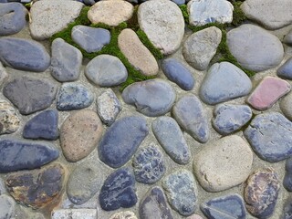 Gray stone wall texture. Textured gray stone wall made by small rounded pebbles