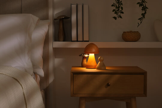 Stylish living room interior with bed, bedside table and night light
