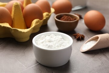 Baking powder, anise stars, eggs and cocoa on grey textured table, closeup