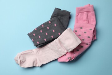 Different child's tights on light blue background, flat lay