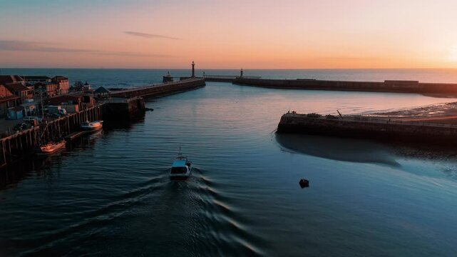 Drone Shot of Working Fishing Boat leaving Whitby Harbour at Sunrise UK