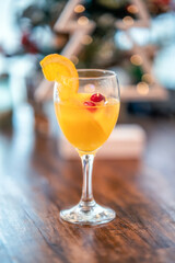 Festive holiday mimosa cocktail with an orange slice and cranberry