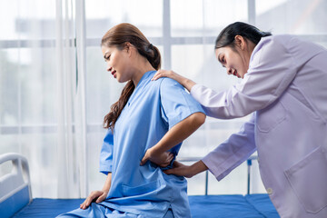 Fototapeta premium A woman in a blue hospital gown is being treated by a nurse