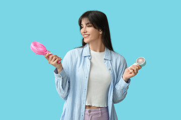Young woman with mini fans on blue background
