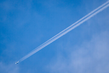 Airplane clouds stretching straight up into the sky