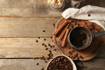 Composition with cezve with hot brewed coffee on tray and sugar on wooden background