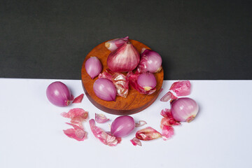 Red onion on wooden bowl isolated on black and white background.