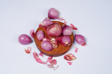Red onion on wooden bowl isolated on white background.