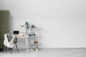 Messy workplace with laptop and papers in office