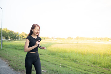 A woman is running in a field with a bright sunny day