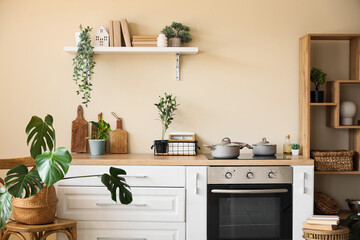 White counters, oven, shelving unit and utensils in interior of beautiful kitchen